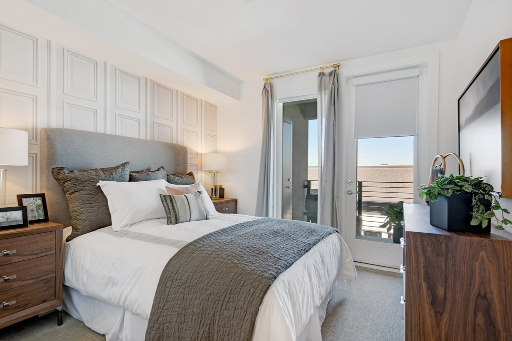 a bedroom with a bed and a door to a balcony