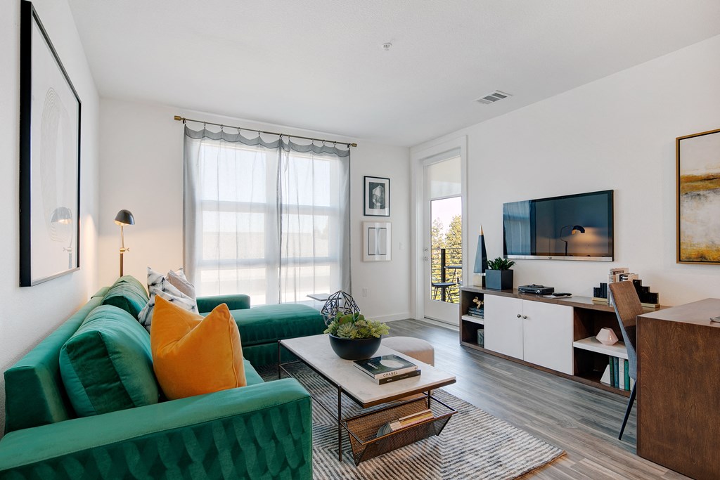 a living room with a green couch and a television