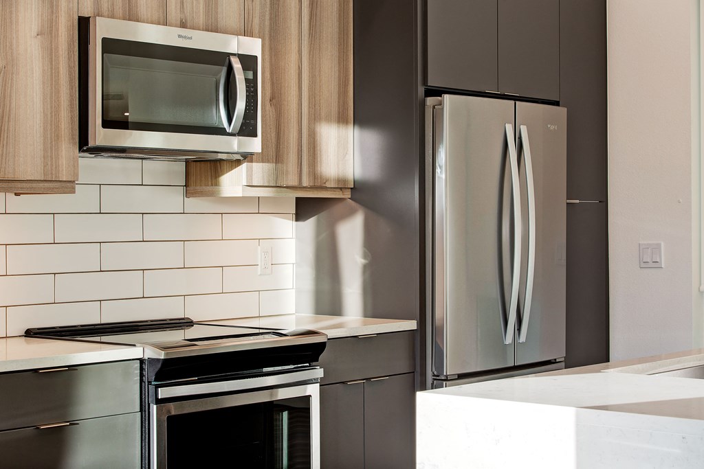 a modern kitchen with stainless steel appliances and a microwave