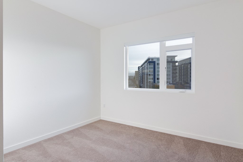 an empty room with a window overlooking a city