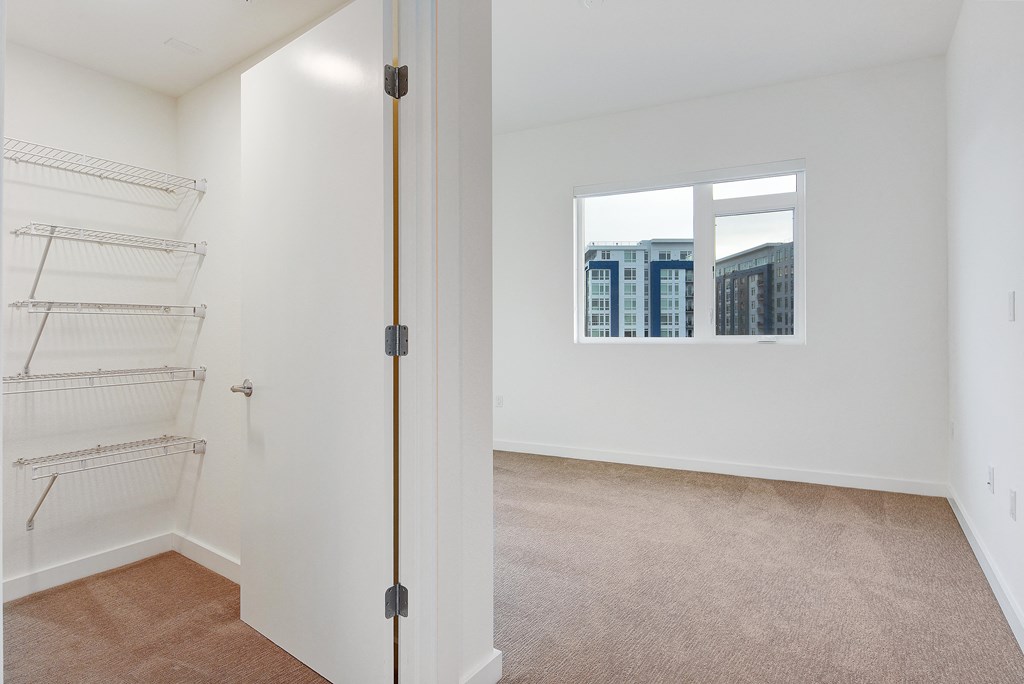 an empty room with a closet and a window