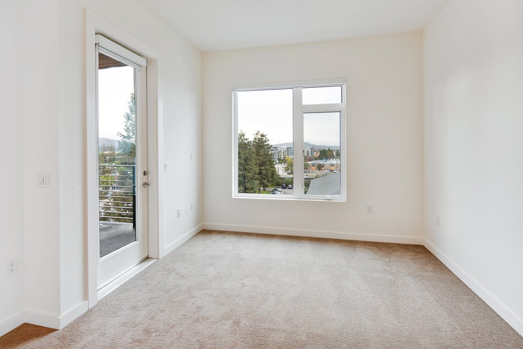 an empty room with a window and a door