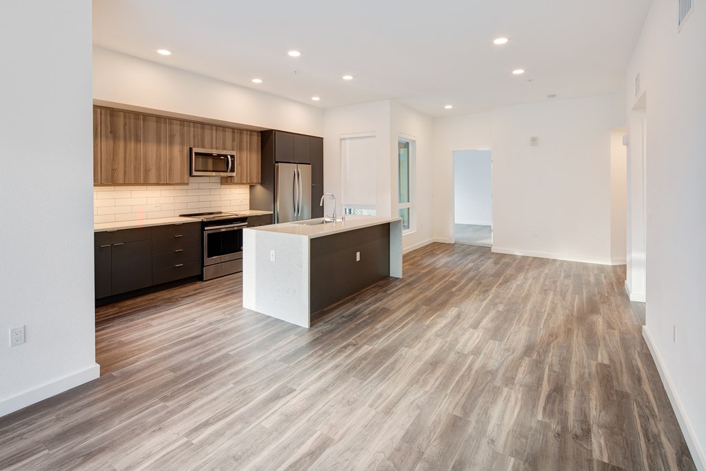 a kitchen and living room in a new home with wood flooring