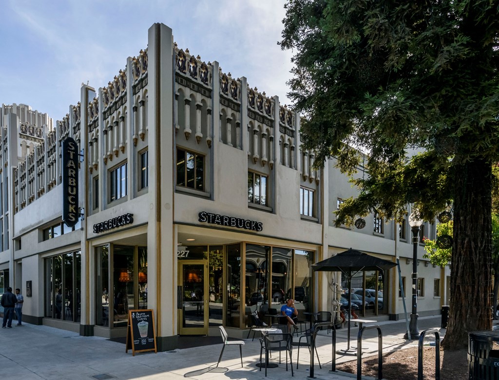 the facade of a building with tables and chairs in front of it