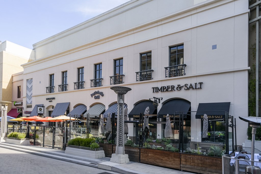 a large white building with tables and umbrellas in front of it