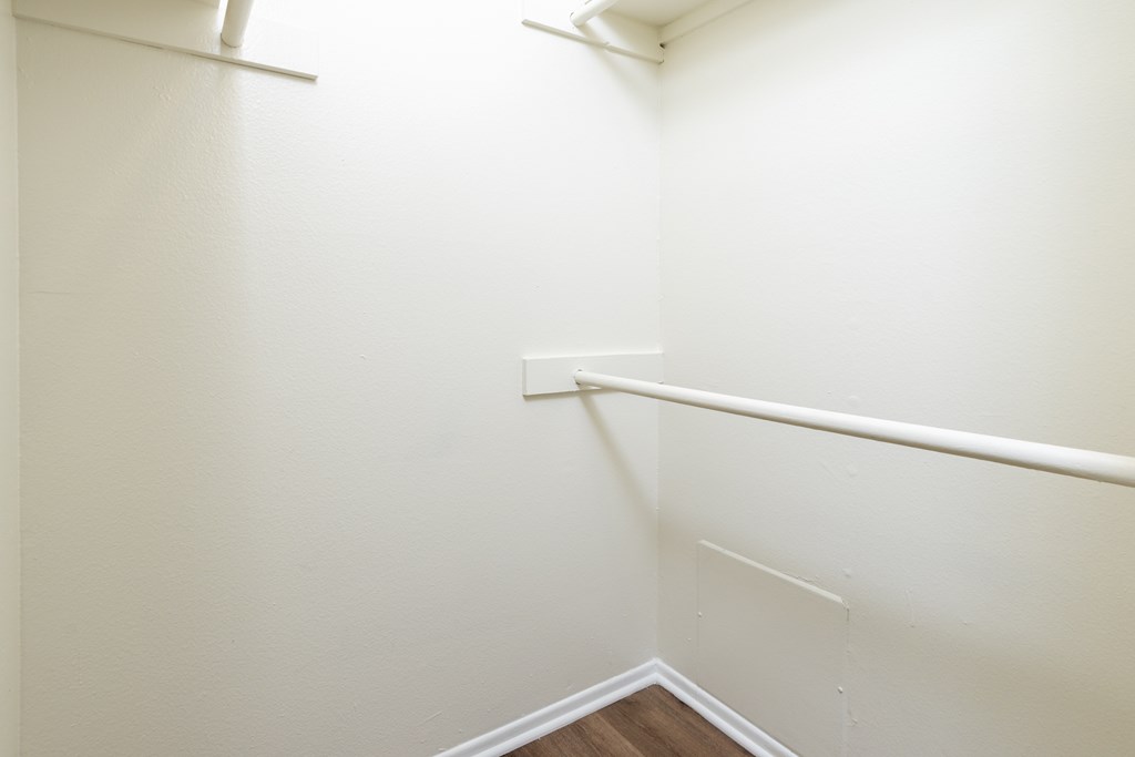A white wall with a corner and a white baseboard.