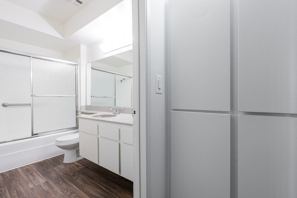 a white bathroom with a shower toilet and sink
