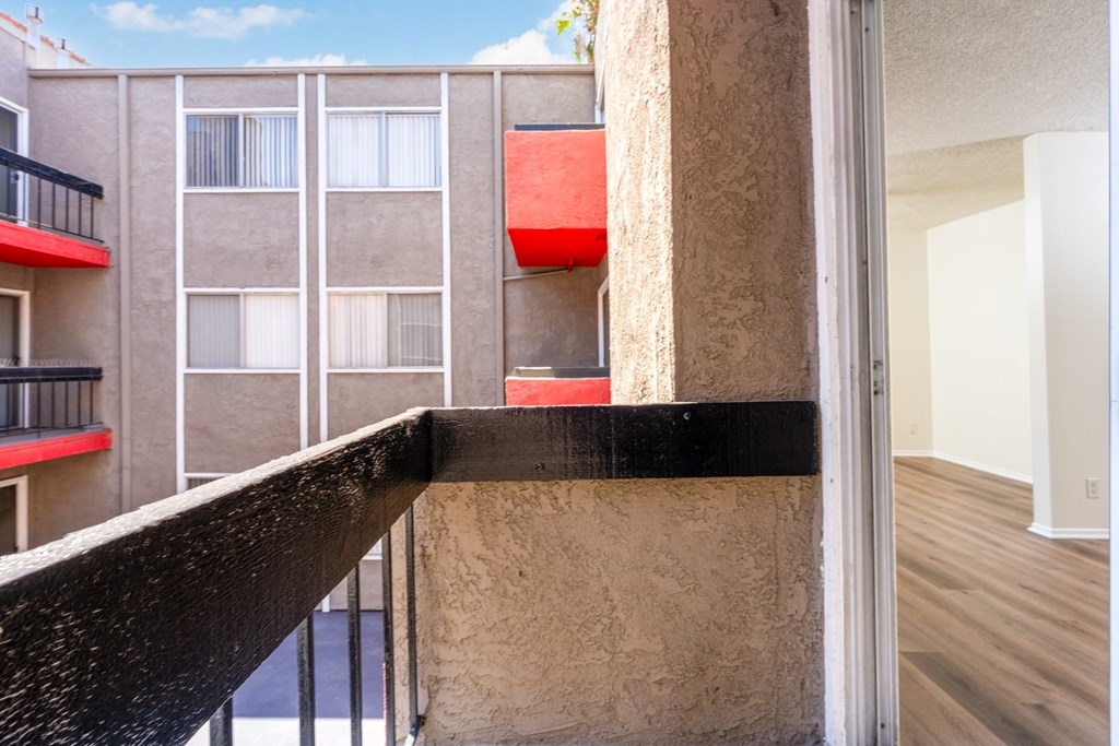 A balcony with a black railing and a red object on the wall.