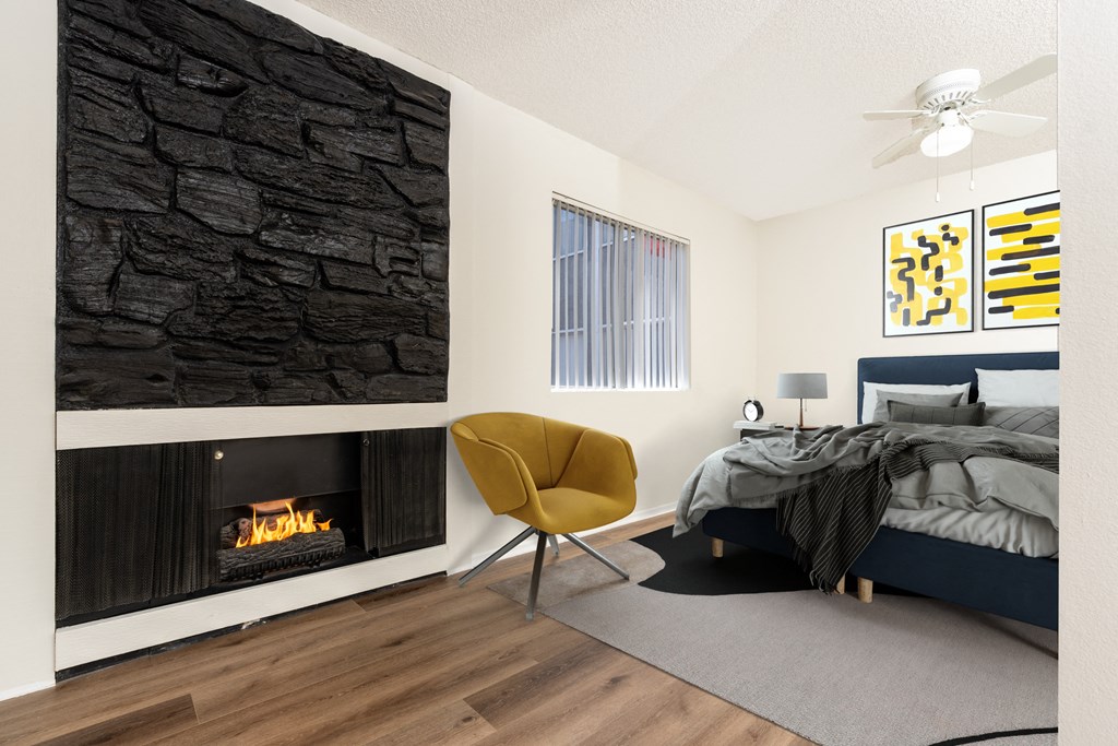 A modern bedroom with a stone wall and a yellow chair.