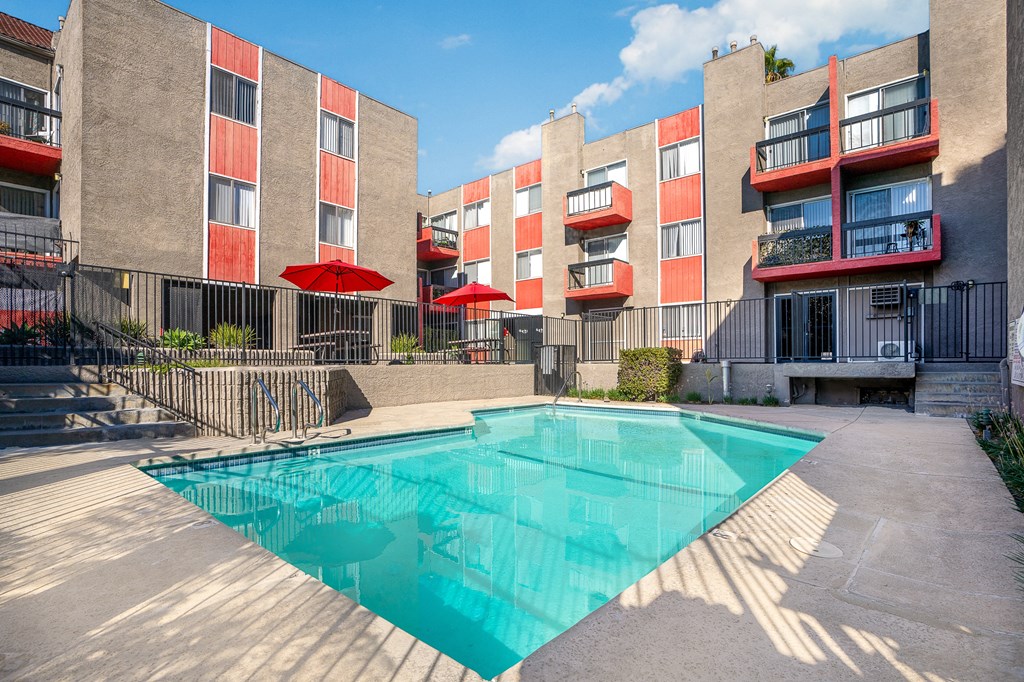 an apartment building with a pool in front of it