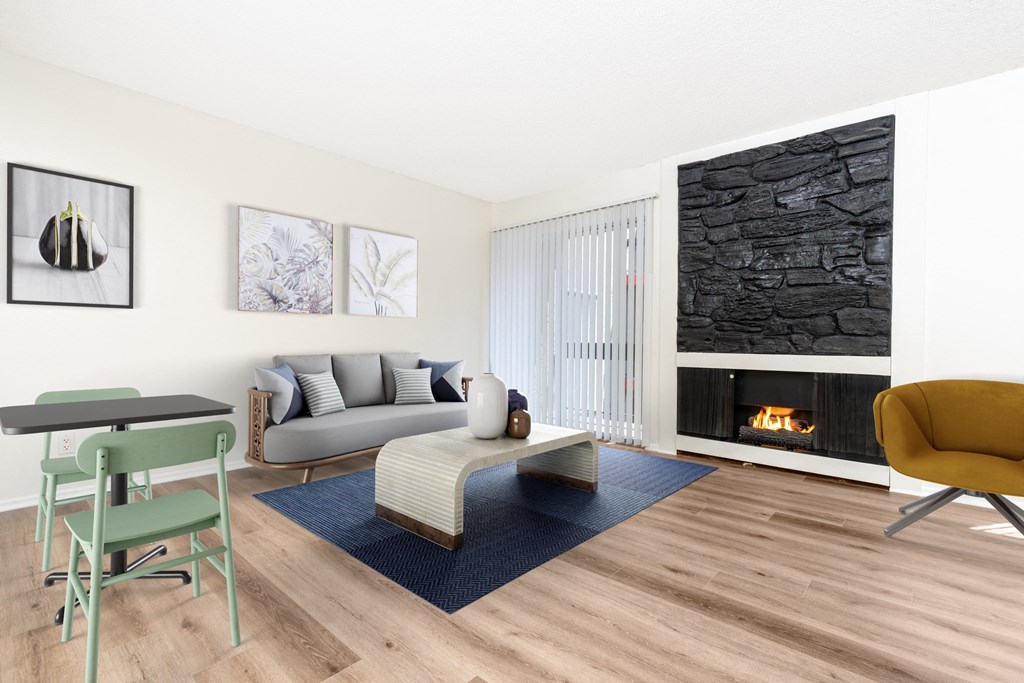 A living room with a fireplace and a grey couch.