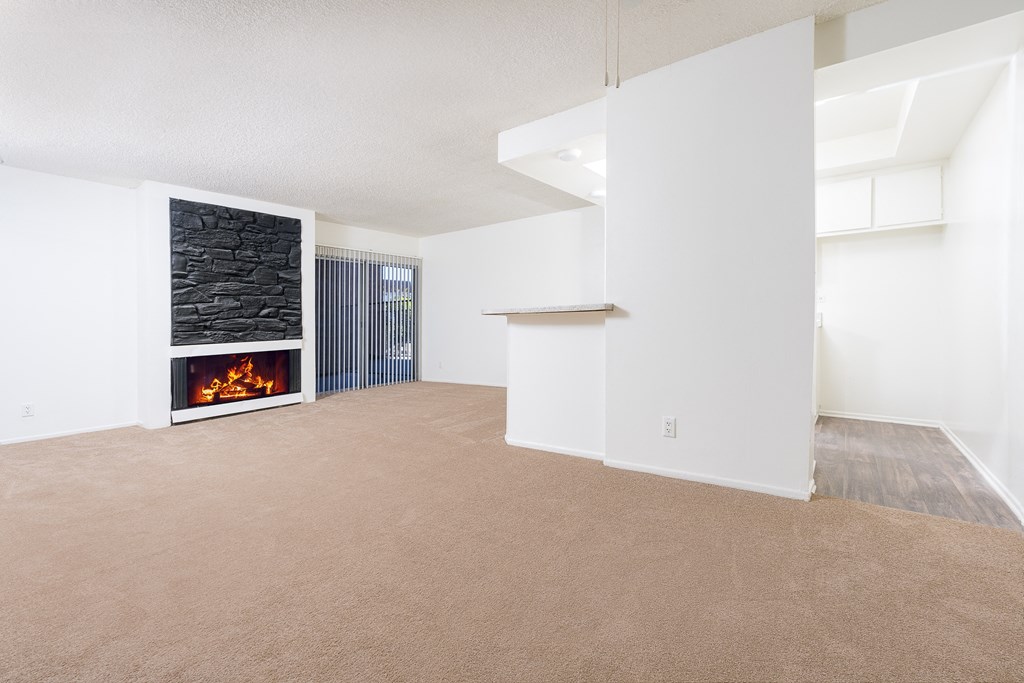 an empty living room with a fireplace and white walls