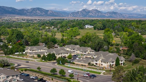 A suburban neighborhood with houses and cars, with mountains in the background.