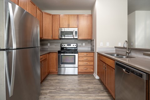 A modern kitchen with wooden cabinets and stainless steel appliances.