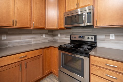 A kitchen with wooden cabinets and a black stove top oven.