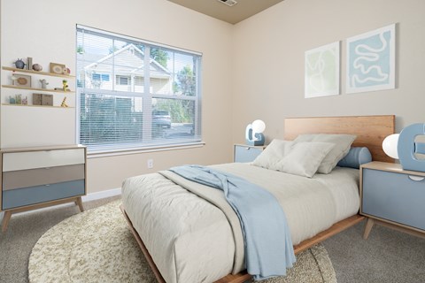 A bedroom with a bed, nightstand, and window.