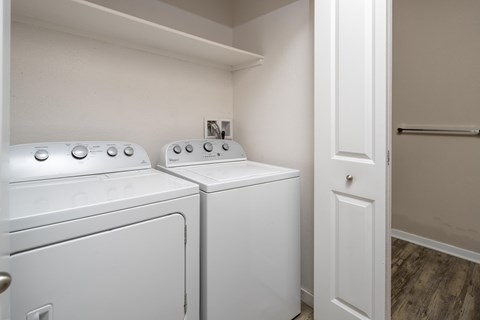 Two white washing machines in a small laundry room.