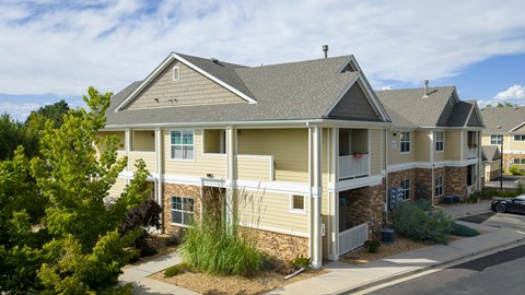 A house with a grey roof and a white fence.