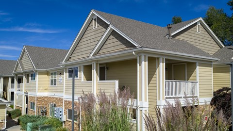 A house with a grey roof and a yellow wall.