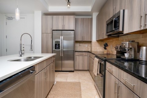 A modern kitchen with wooden cabinets and stainless steel appliances.