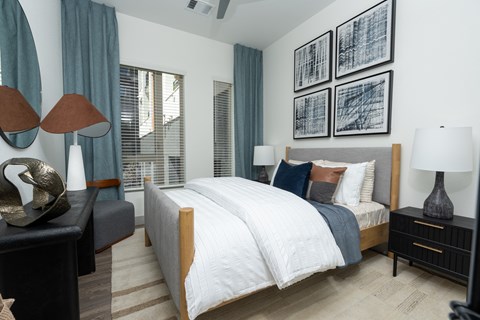 A bedroom with a large bed and a painting above it.