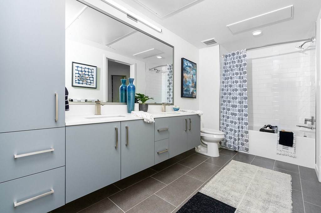 a bathroom with white walls and grey tiles