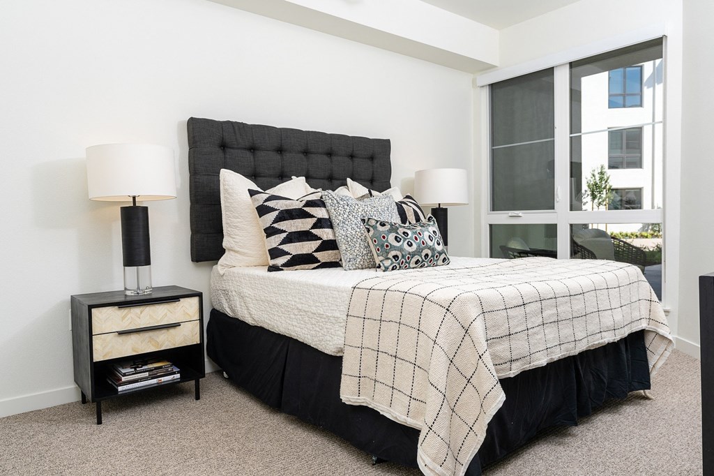 a bedroom with white walls and a large window