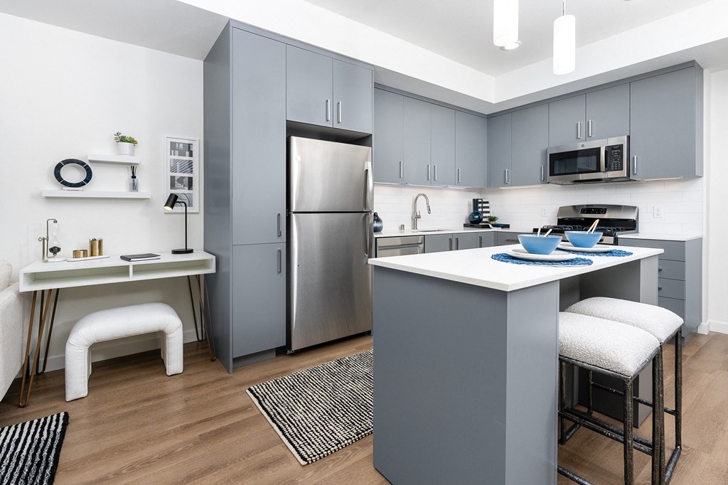 a kitchen with gray cabinets and a white counter top