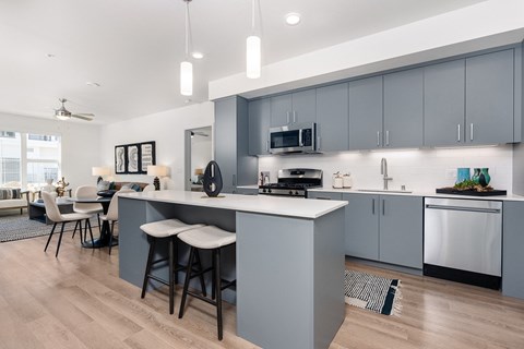 a kitchen and living room with blue cabinets and a counter top