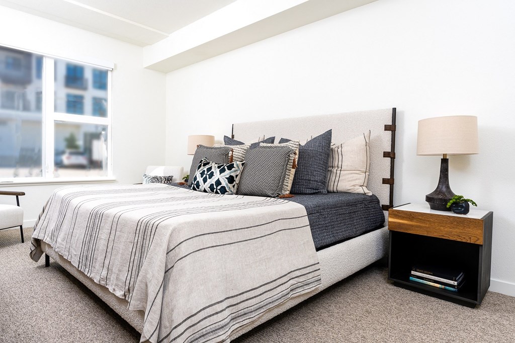 a bedroom with white walls and a large window