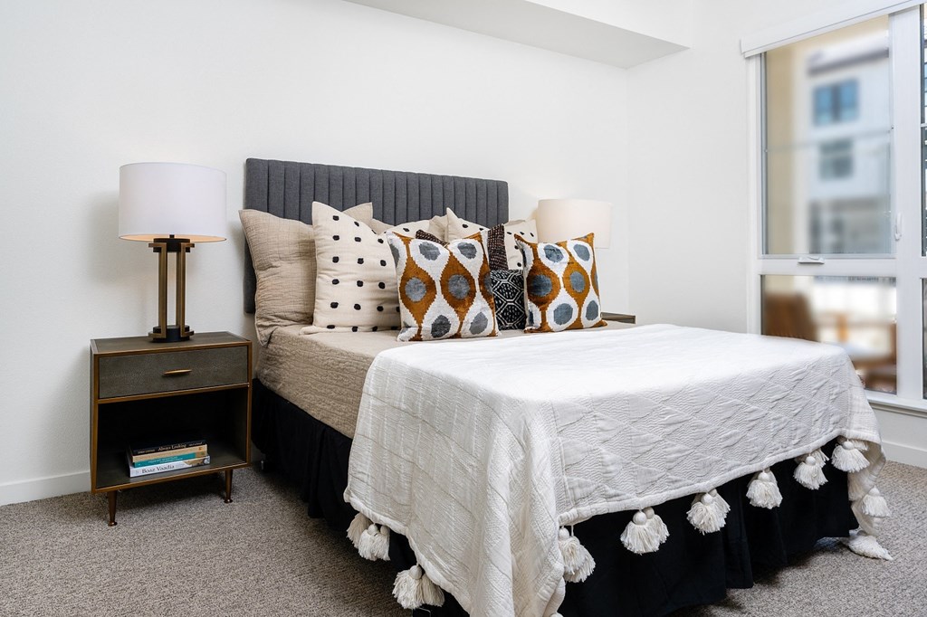 a bedroom with a bed and a nightstand with two lamps