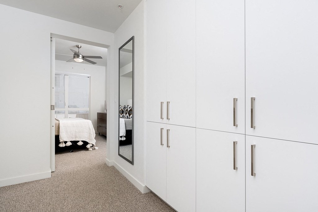 a bedroom with white cabinets and a white ceiling fan