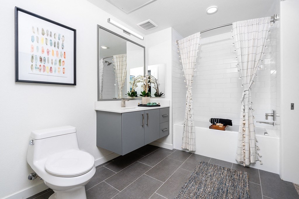 a bathroom with white walls and grey tiles