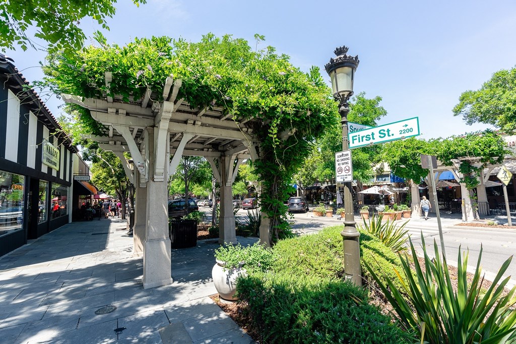 a city street with a stone archway and a street sign with a street name on it