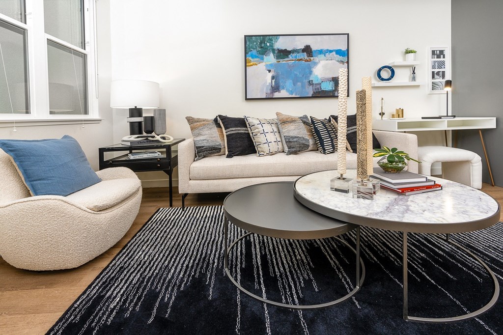 a living room with a white couch and a black and white rug