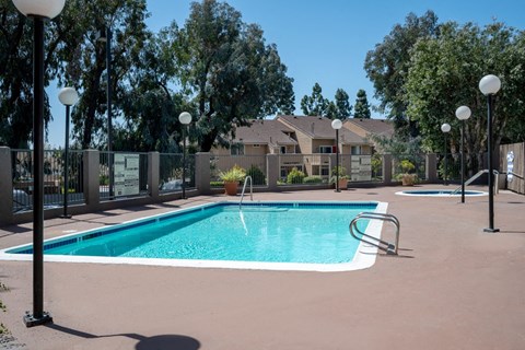 a swimming pool with trees and apartments in the background