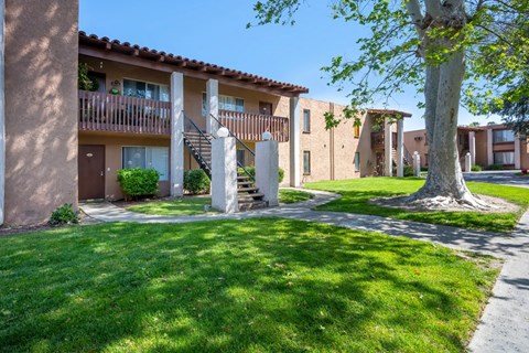 a building with a staircase and a yard in front of it