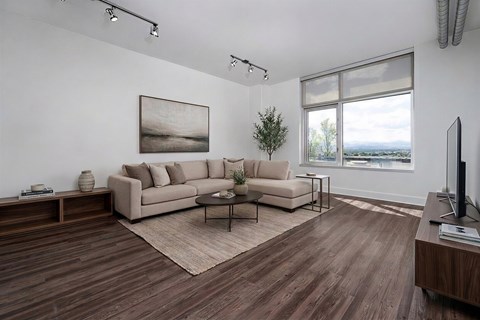 A living room with a couch, a coffee table, and a painting on the wall.