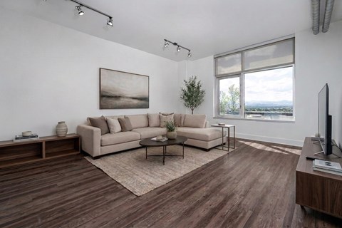 A living room with a large couch and a painting on the wall.