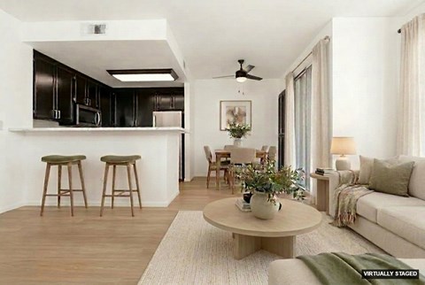 A living room with a white couch, a coffee table, and a dining table with chairs.