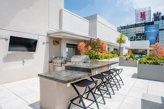 a patio with a bar and stools and a television - Photo Gallery 2