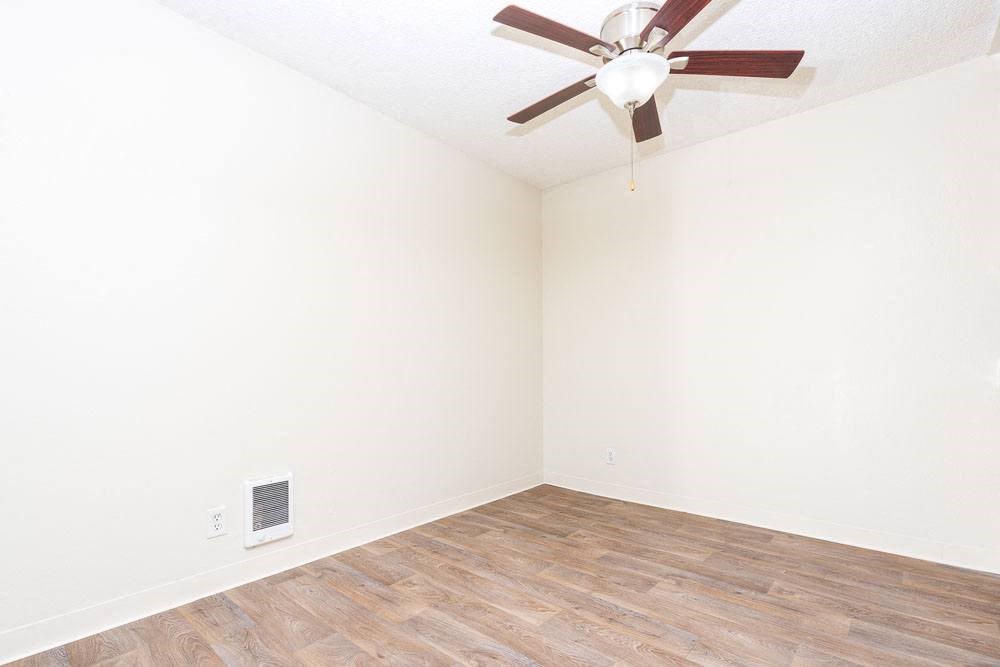 an empty room with white walls and a ceiling fan
