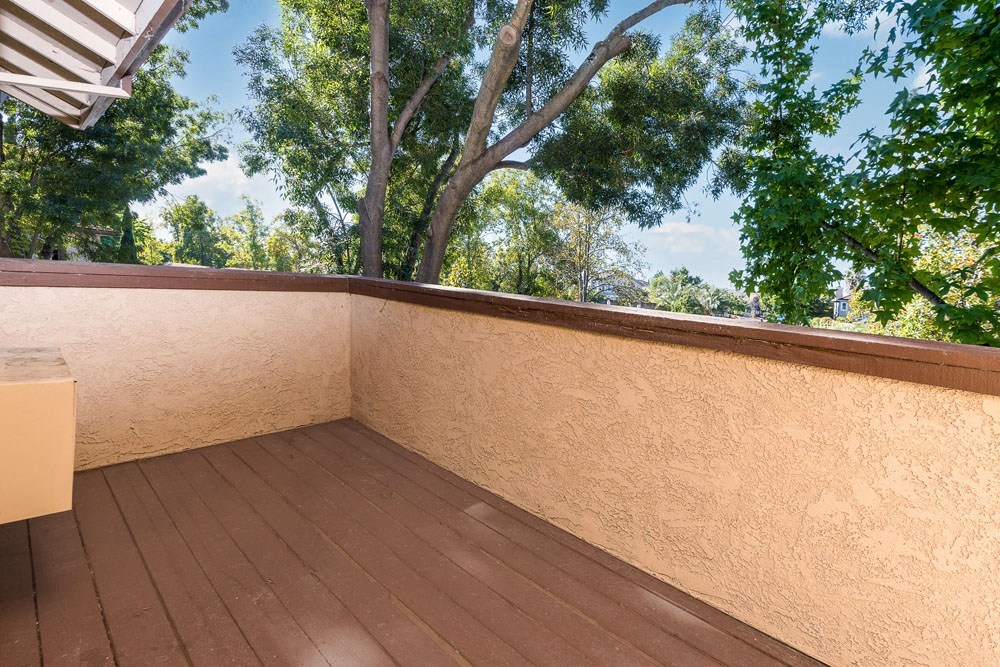a balcony with trees and a wooden floor