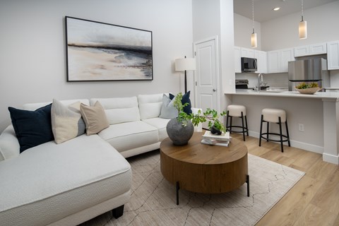A living room with a white couch and a coffee table in the center.