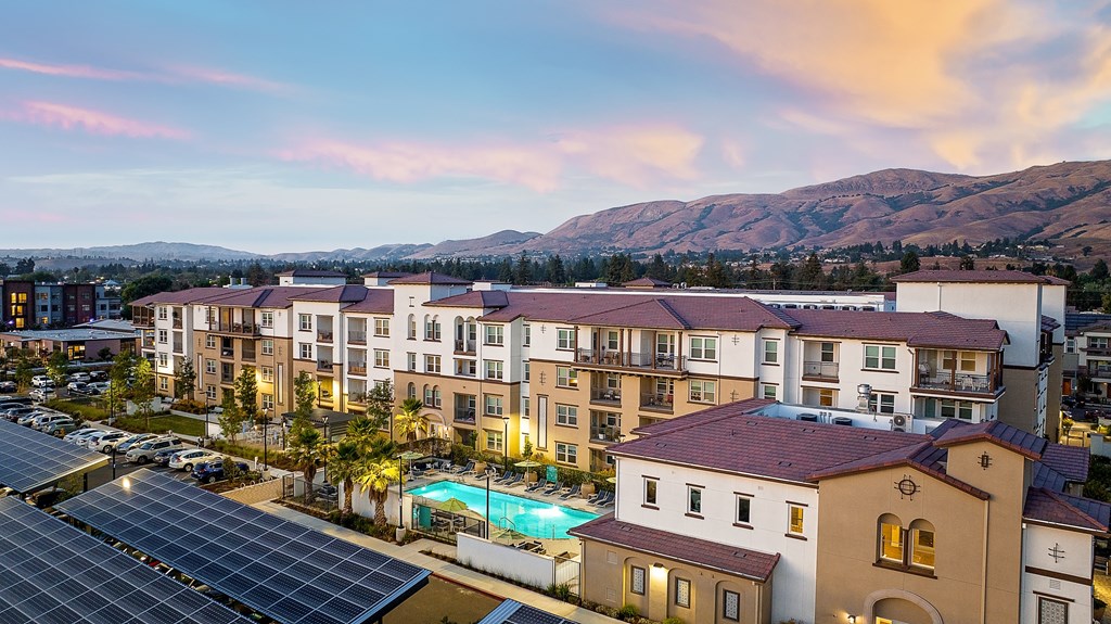 an aerial view of an apartment complex with a pool and solar panels