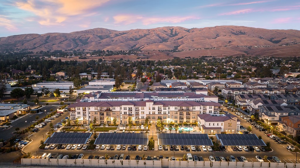 an aerial view of a large building with mountains in the background