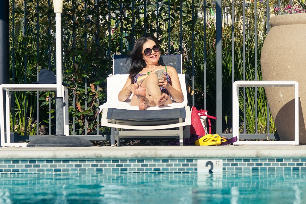 a woman sitting in a chair next to a swimming pool