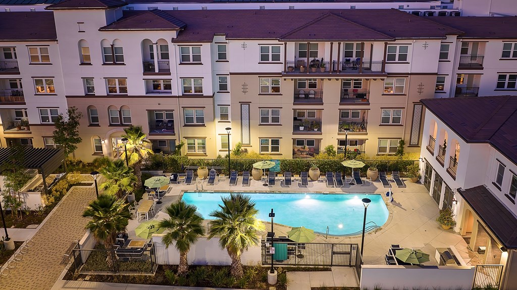 an aerial view of a swimming pool in front of an apartment building