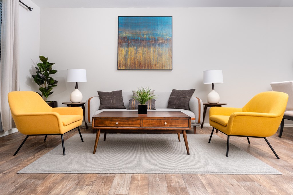 a living room with yellow chairs and a table