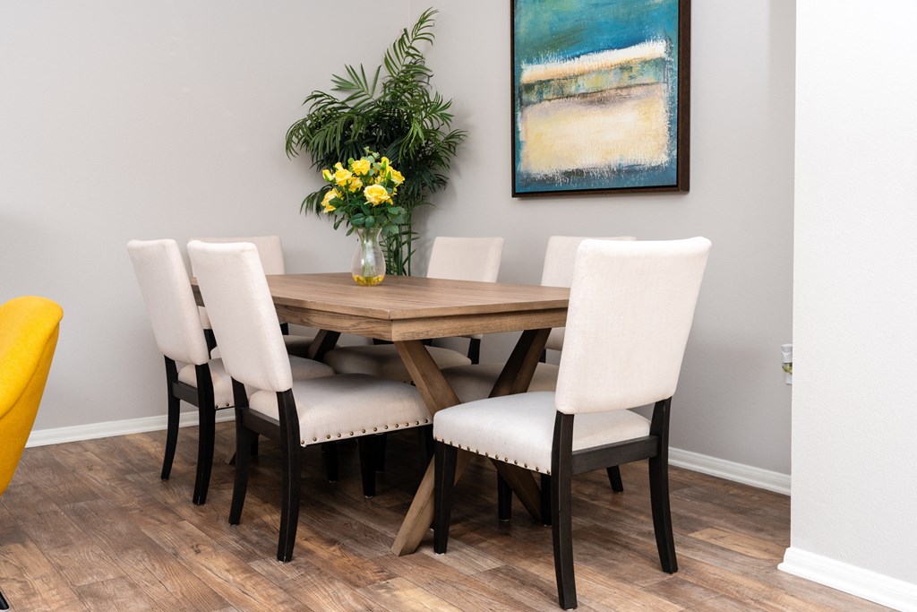 a dining room with a wooden table and white chairs